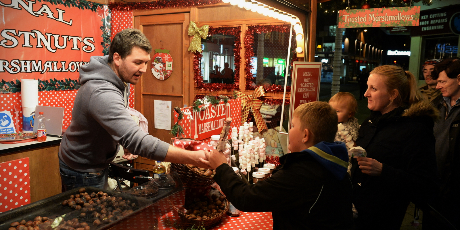 Hombre vendiendo dulces a una familia en una tienda