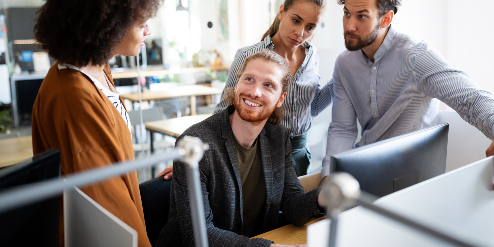 Un equipo de trabajo conversando y riendose mientras buscan un buen software de crm para la empresa.