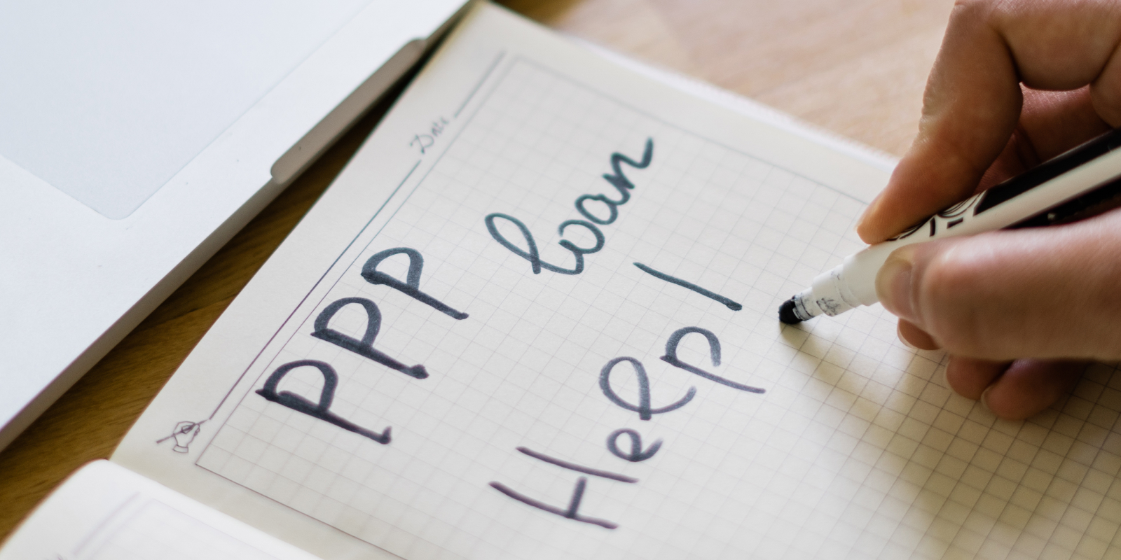 ppp loan help escrito en un pedazo de papel.