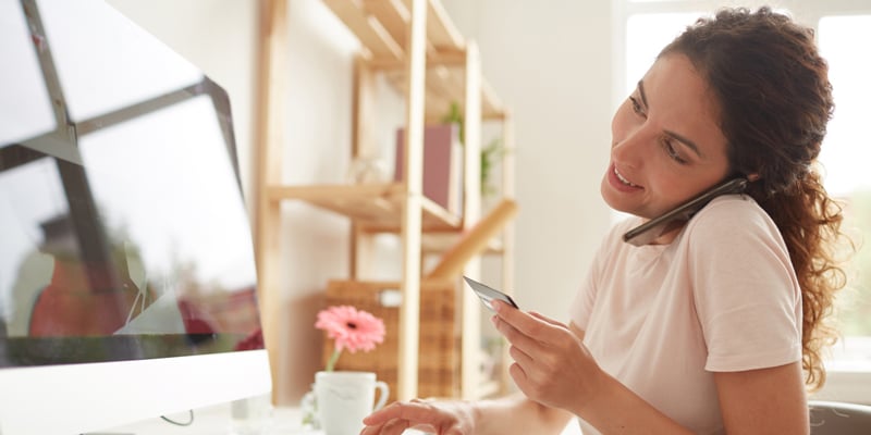 Mujer dictando los digitos de su tarjeta de credito.