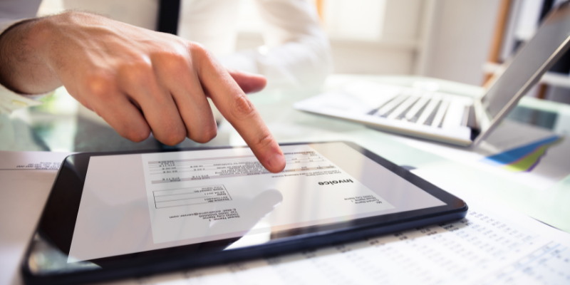 Business owner creating an invoice on an ipad. 