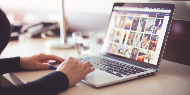 Mujer subiendo fotos a las redes sociales desde su portatil.